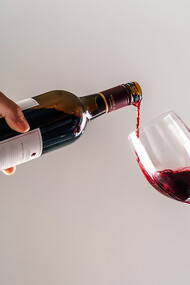 A person gracefully pouring wine into another's hand, capturing the essence of hospitality and shared enjoyment