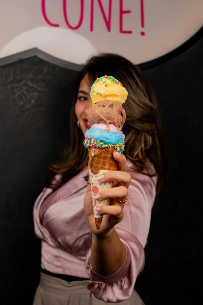 A woman’s hand gently holding an ice cream cone sprinkled with sugar crystals