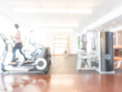 Vista sfocata di una persona che cammina su un tapis roulant in una palestra luminosa
