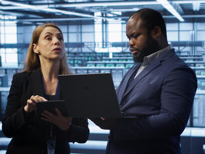 A data center engineer demonstrating critical infrastructure to an inspector, ensuring secure operations and compliance in the realm of cybersecurity and data protection