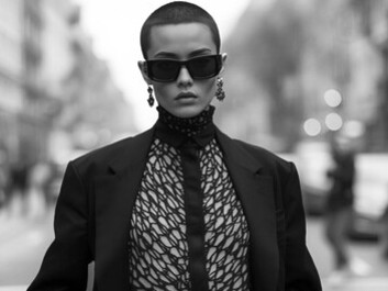 A street-style model embodies genderless fashion, dressed in a coat