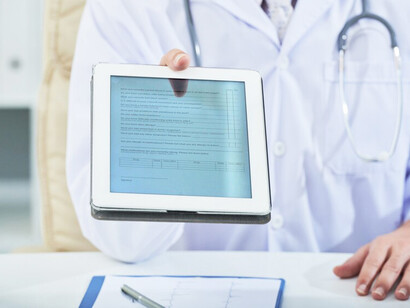 A doctor using a digital tablet to discuss a medical diagnosis and guide the patient's health journey