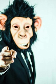 Human being posing as a monkey while wearing a suit