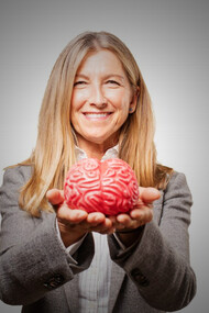 A woman holding a brain in her hands, symbolizing the complex decision-making processes discussed in the article