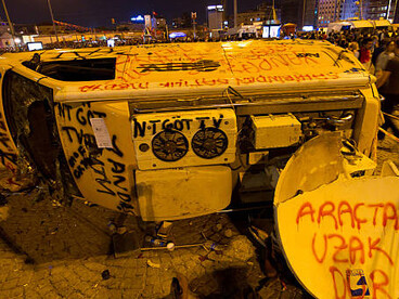 An overturned car covered in graffiti during the protests in Türkiy, 2013