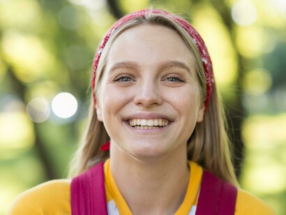 Primo piano frontale di una giovane donna che sorride apertamente