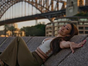 Woman posing near the Sydney Harbour Bridge at sunset, New South Wales, Australia