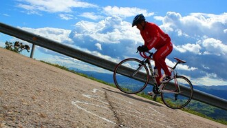 Un ciclista asciende por la escarpada pendiente de Peña Cabarga