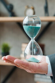 A businessman holding an hourglass in his office