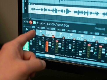 A person interacting with a screen through voice commands as part of a sound installation