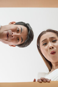 A couple opens a box together, excitedly examining the product inside