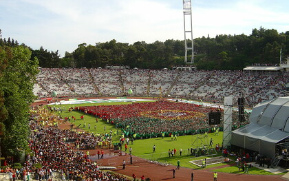 Estádio Nacional do Jamor durante o evento "A mais bela bandeira do mundo" - promoção da participação portuguesa no Mundial de Futebol 2006. No que diz respeito à Liga Portuguesa, uma alteração importante seria a mudança de horários dos jogos. Atualmente, muitos jogos ocorrem à noite, dificultando a ida das famílias aos estádios. Realizar os jogos ao fim de semana, durante a tarde, tornaria os estádios mais acessíveis para um público mais amplo, promovendo um ambiente familiar e inclusivo. Além disso, ao realizar os jogos nesse horário, as cidades vizinhas aos estádios poderiam beneficiar do aumento do turismo e da movimentação social, promovendo o futebol como uma atividade divertida para todas as idades