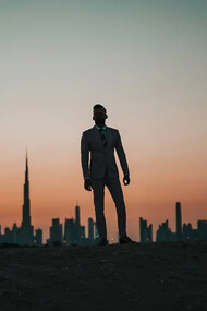 A man standing against the backdrop of Dubai’s iconic city skyline