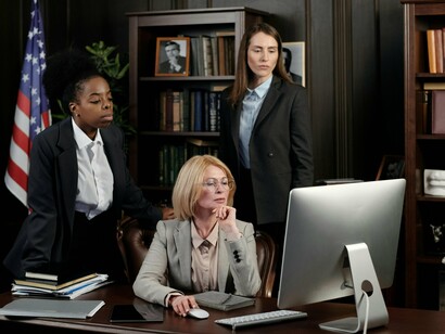 A woman leading with confidence among her peers, illustrating the normalization of women’s authority in formal institutions