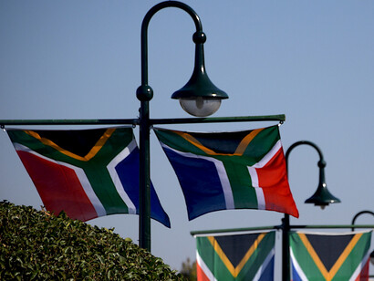 As the South African flag flutters at the Union Buildings in Pretoria, South Africa, it reflects the nation’s pivotal moment in history following the 2024 elections, which reshaped the political landscape with a renewed coalition government