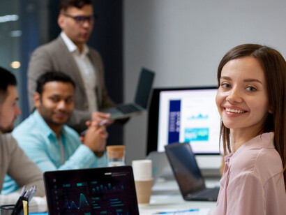 Individuals in the office, leveraging computers to explore real estate data visualizations and property market analytics powered by AI technology