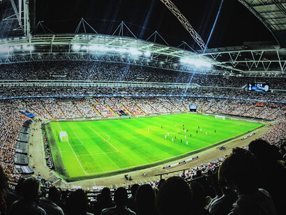 L’ambiance électrisante de Wembley Stadium à Londres au Royaume-Uni, illuminé pour un match de football en soirée devant une foule impressionnante