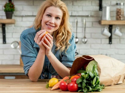 In a kitchen full of colorful vegetables, a woman is busy preparing a healthy meal