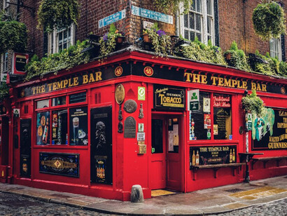 A red building adorned with numerous plants on its rooftop, located in the Temple Bar area of Dublin, Ireland