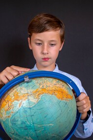 Menino estuda o globo