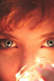 A woman holding a lightbulb to her face expressing her desire for the light