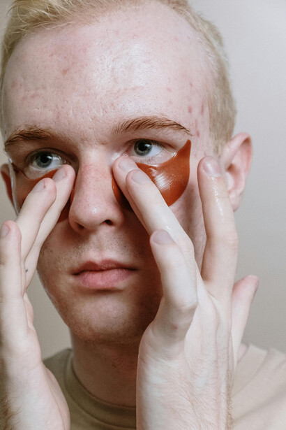 A man practicing his skincare ritual with nourishing fall serums and creams