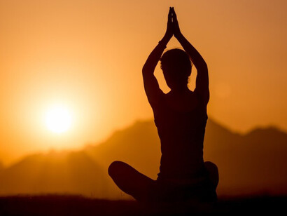 Practicing yoga amid mountain landscapes at sunset, reflecting spiritual harmony, mindful awareness, intuitive insight, and the presence of unseen energy flows