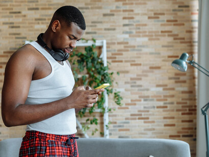 A person is alone at home, looking at his phone, embodying a sense of individualism