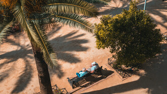 Two elderly people sitting on a metal bench on a warm summer day in Córdoba, Spain