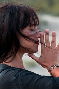 Mulher meditando enquanto brisa assopra seus cabelos