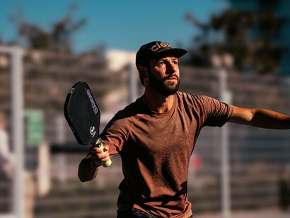 With his paddle ready, a determined athlete prepares to strike the ball, highlighting the importance of strength training for powerful shots in pickleball