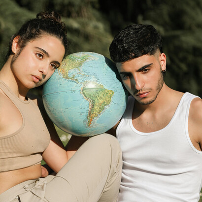 A poetic depiction of a couple standing in nature with a globe, celebrating human coexistence and harmony with the natural world