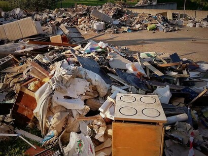 Parcheggio trasformato in discarica temporanea dei rifiuti provenienti dalle case degli abitanti dopo l'alluvione, che permette di visualizzare i danni materiali in zona, San Lazzaro di Savena (BO), Italia