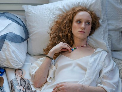 A woman motionless on her bed as thoughts churn internally, representing the psychological cost of constant self-criticism