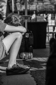 Menino triste nas ruas da cidade