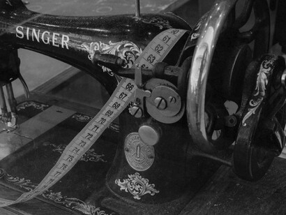 The robust and ornamented design of this old sewing machine symbolizes the pivotal role of early technology in shifting fashion production from artisanal craft to industrial scale