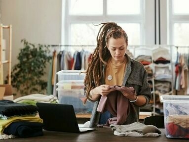Mulher trabalha em loja de roupas de segunda mão. O crescimento das plataformas de venda de roupa em segunda mão, como a Vinted, e o interesse por peças vintage são sinais claros de uma mudança cultural. Reutilizar, reparar e trocar roupas são atitudes que fazem parte de um novo estilo de vida, mais sustentável e consciente

