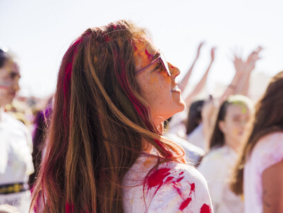 A young woman at a festival, sprayed with paint