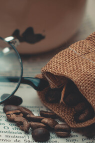 Xícara de café sob a mesa para acompanhar a leitura de um livro