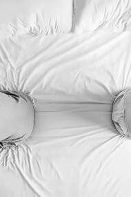 A couple sits on the bed, separated by their fear of intimacy