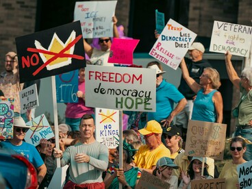 Protesters standing shoulder to shoulder with constitutional slogans, symbolising the persistence of participatory democracy