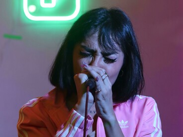 Singing karaoke in a bar, a girl uses music as a fun and engaging way to practice a new language