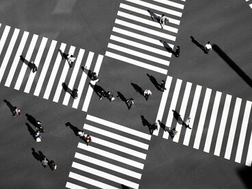 Silhouetted figures at a crossroads in an urban landscape