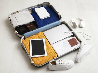 A carefully packed suitcase holds the essentials of a life lived across borders, blending practicality with personal ritual