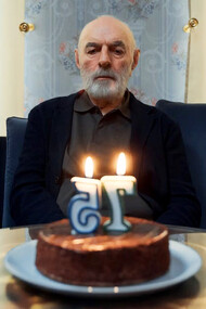 A solitary elderly gentleman, with a hint of nostalgia in his eyes, quietly extinguishes the birthday candles on his cake, marking another year of his life in solitude