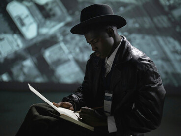 Image of a journalist in black, capturing the risks of working close to power