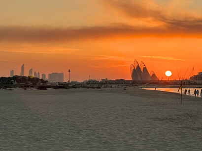 Les ailes emblématiques du Musée national Zayed se détachent dans le ciel orangé d’Abu Dhabi au bord de la mer