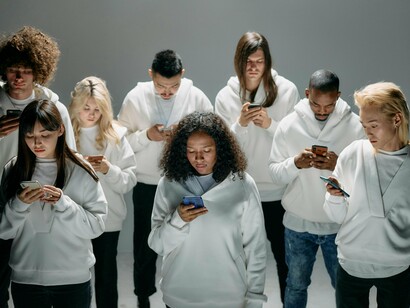 A group of people staring at their screens, symbolising how being always online can disconnect us from one another