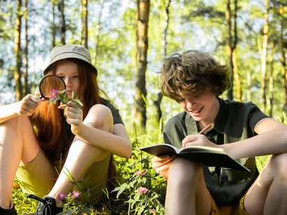 Children absorbed in books outdoors, illustrating how wonder strengthens the ability to adapt