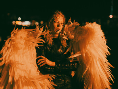 Dramatic night scene of a woman wearing feathered angel wings